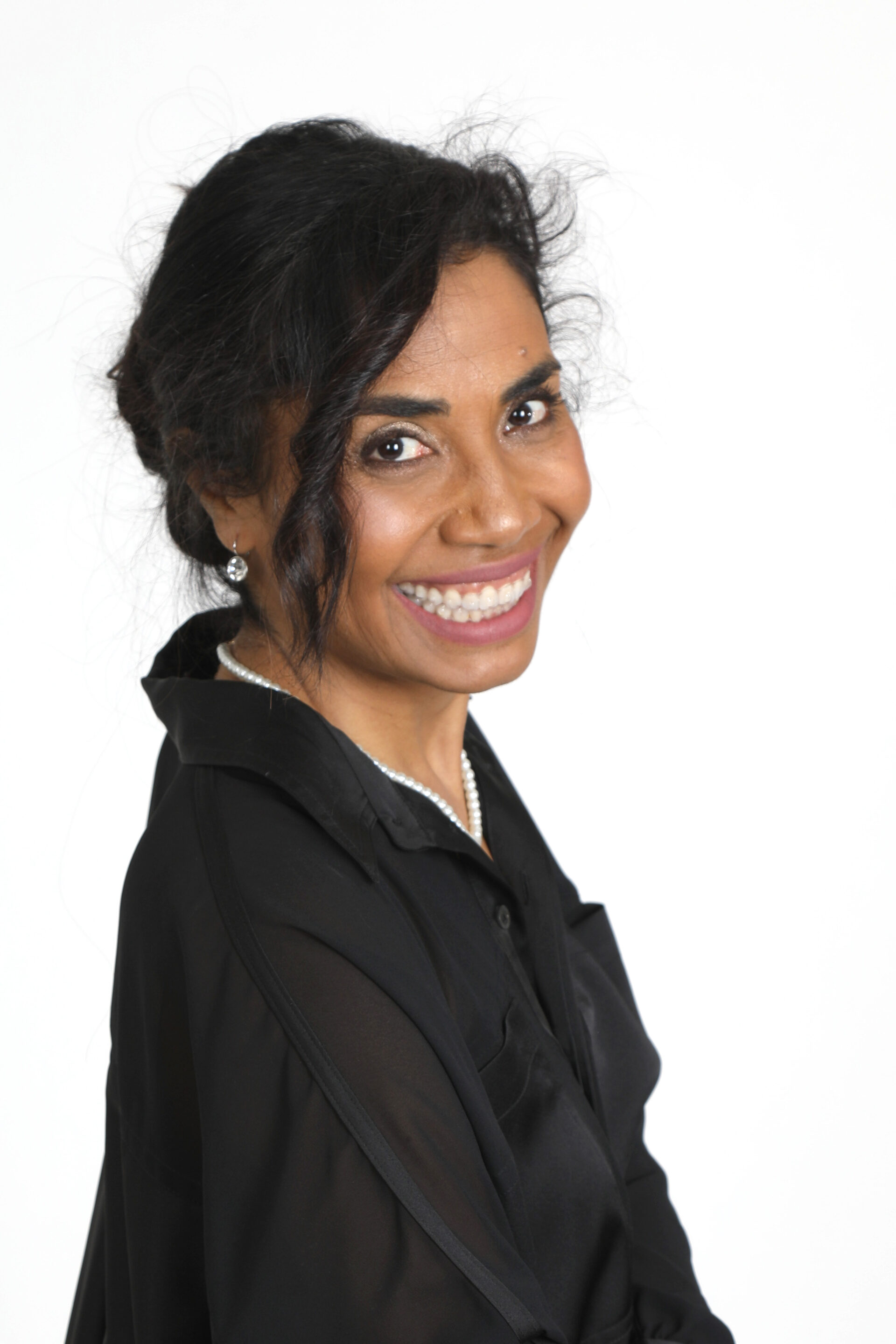 Portrait rapproché et souriant du Dr Joéline Andriana, conférencière et Docteur en Psychologie Sociale. Ce visuel dynamique illustre son approche communicative et inspirante lors de ses conférences sur la haute performance, la gestion du stress et le leadership humain pour les entreprises et institutions.